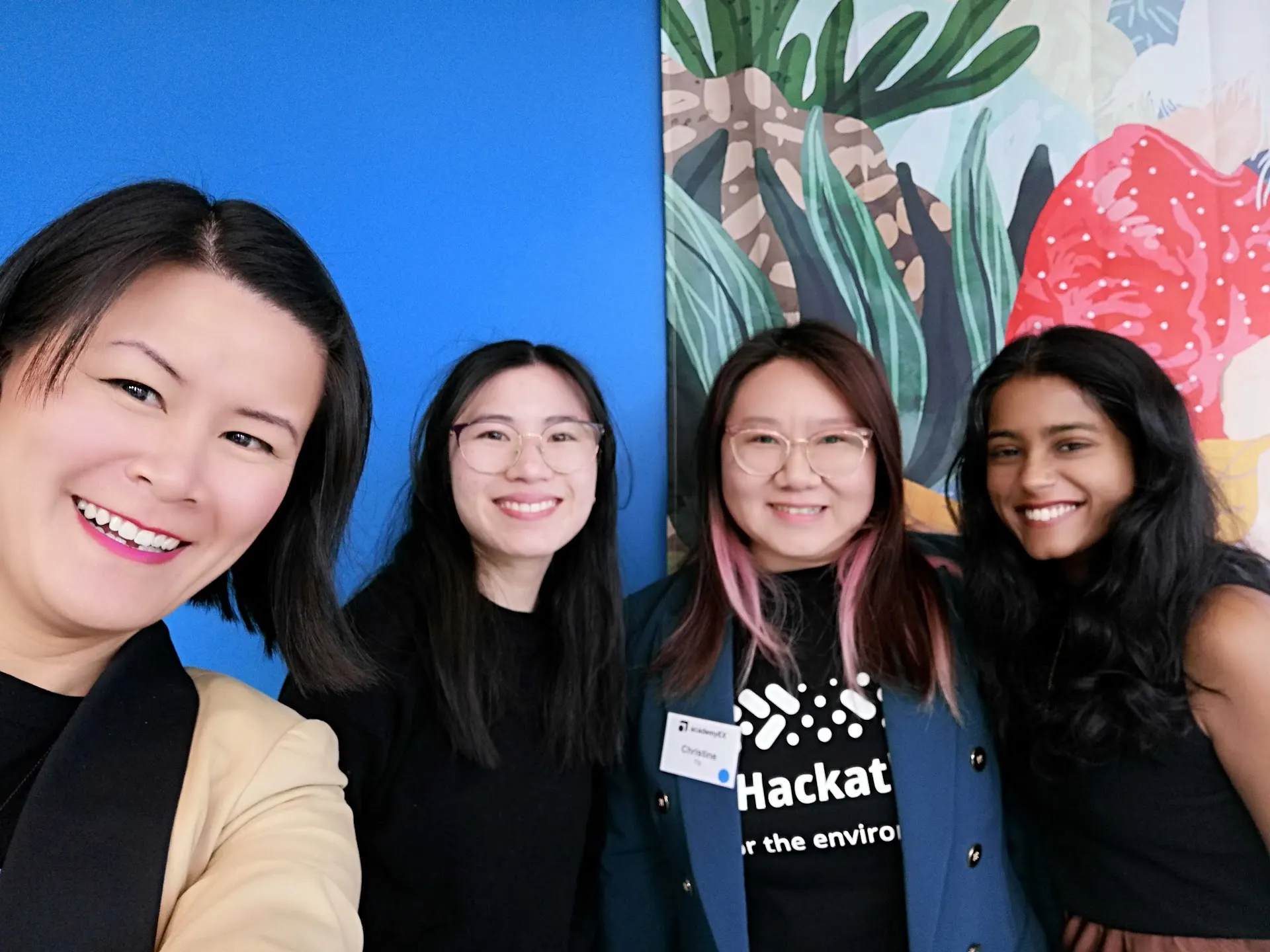 Four smiling women posed closely together at the She Sharp AI for the Environment hackathon.