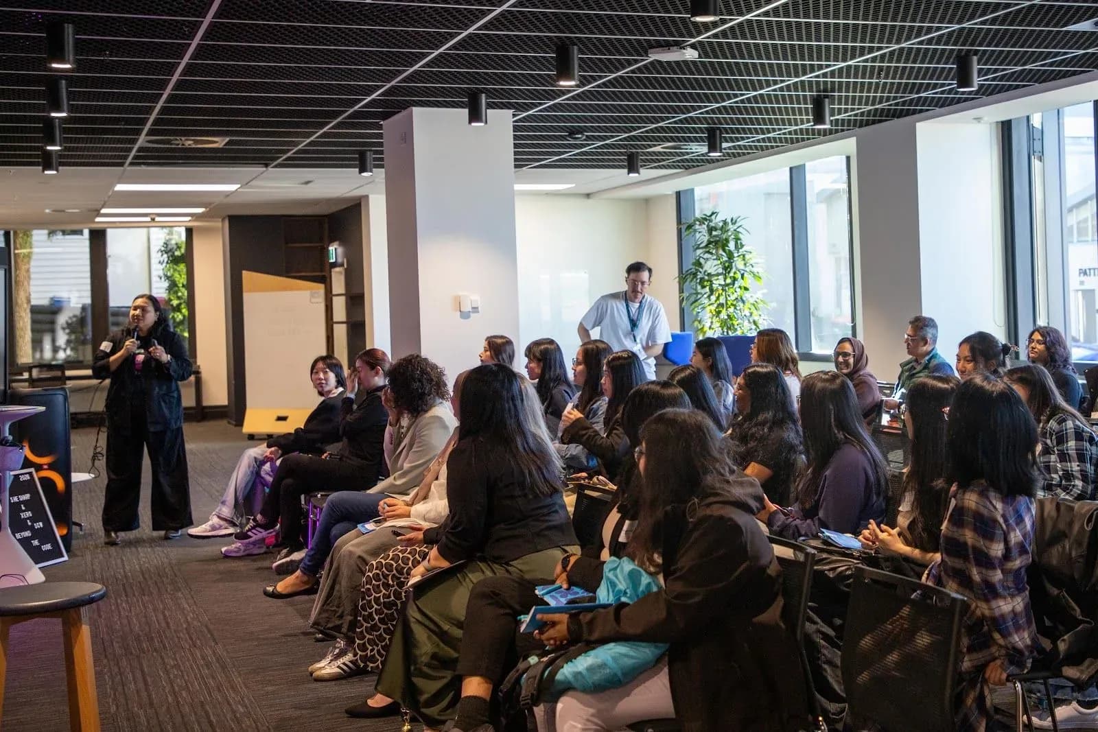A speaker with a microphone addressing a packed room of attendees at Xero's Parnell office